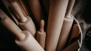 Wooden rolling pins in a container.