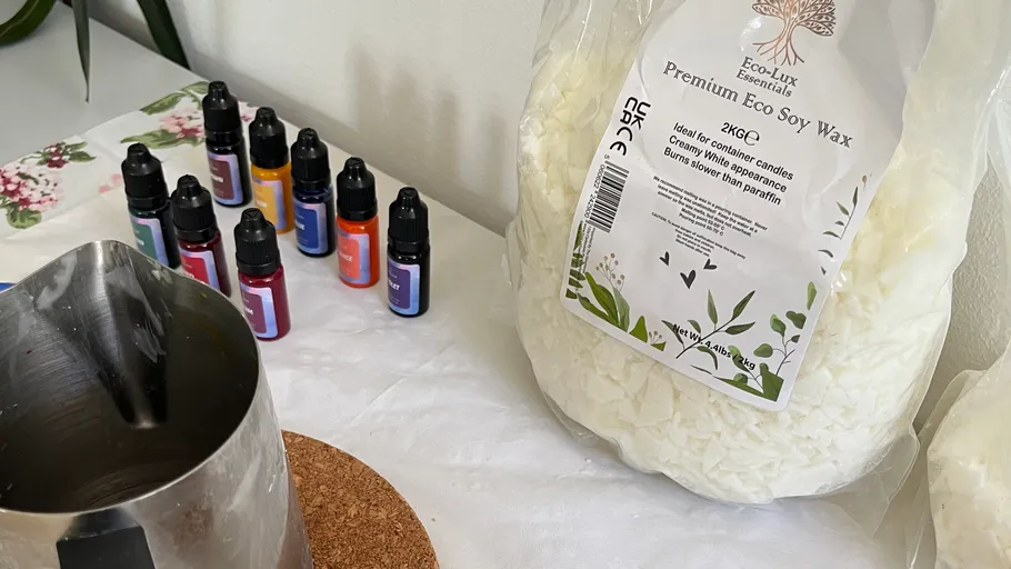 Soy wax and fragrance bottles on table.