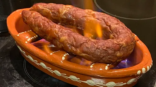 Wurst flammt in einem Tontopf.