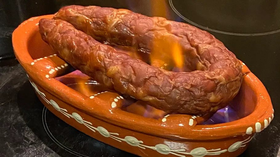 Wurst flammt in einem Tontopf.