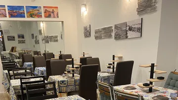 Restaurant mit Tischen, Stühlen und Wandkunst.