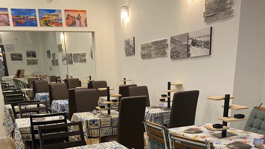 Restaurant mit Tischen, Stühlen und Wandkunst.