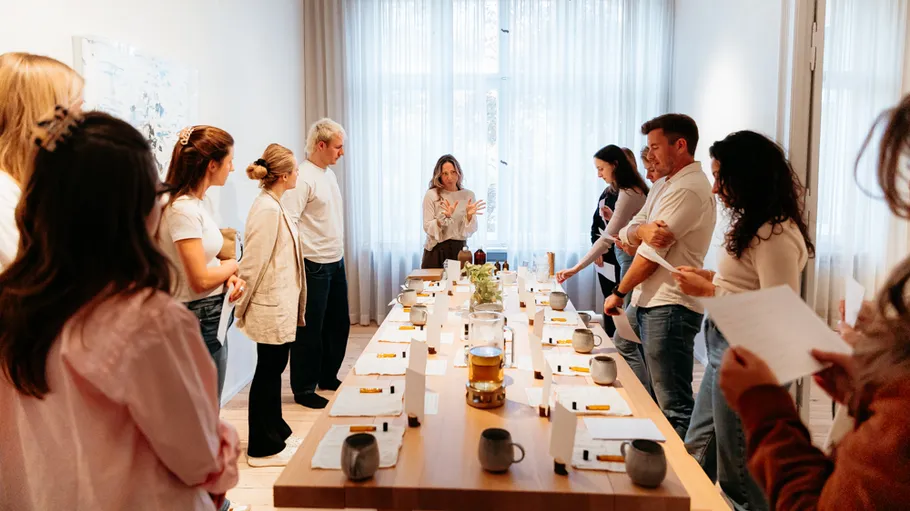 Group meeting around table in bright room.