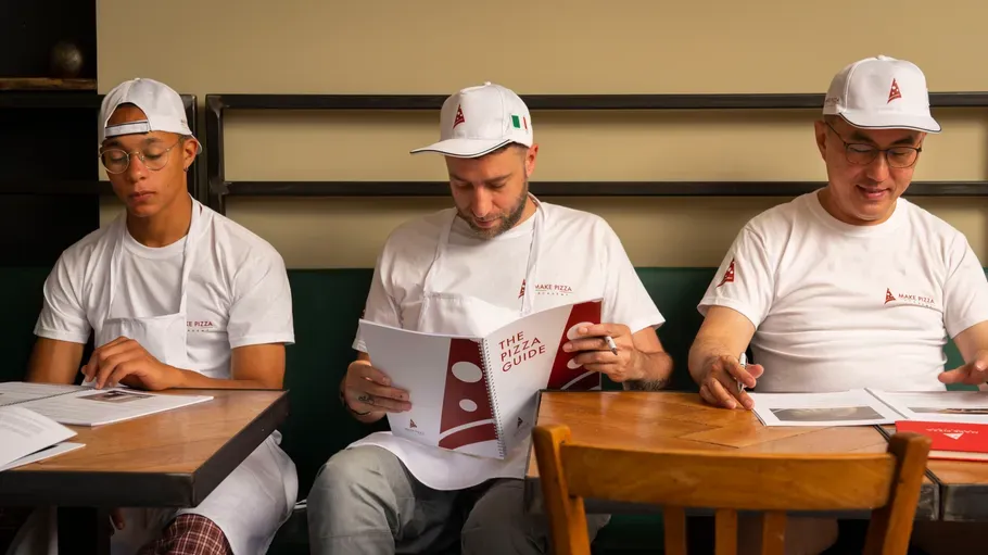Three men reading documents at a table.