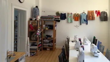 Nähmaschinen auf Tisch in organisiertem Studio.