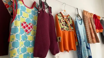 Bunte Kinderkleidung hängt an einer Leine.