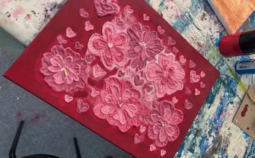 Pink flowers painted on a red canvas.