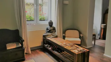Buddha statue on table in peaceful room.