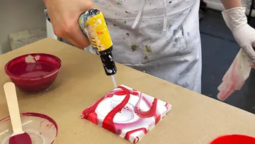 Person using tool to create acrylic artwork.