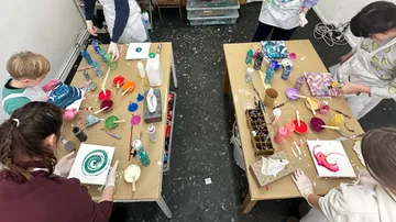 Menschen malen abstrakte Kunst auf Tischen.