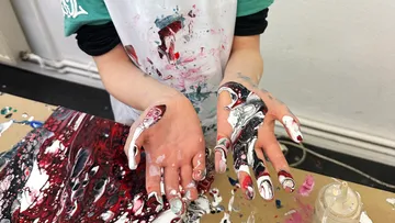 Hands covered in swirling paint patterns.
