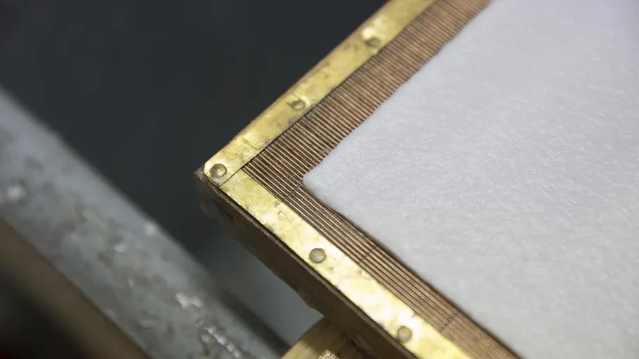 Nahaufnahme eines Papierherstellungsrahmens mit nassem Papier.