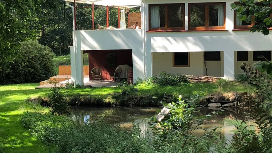 White house near pond and garden area.