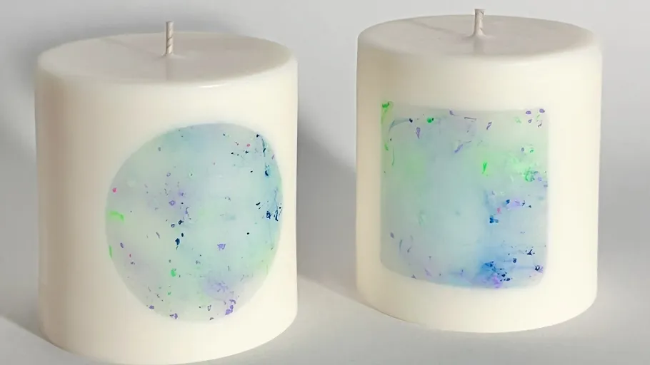 Two candles with abstract art design.