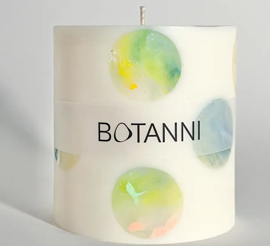 Decorative candle with colorful circle designs.