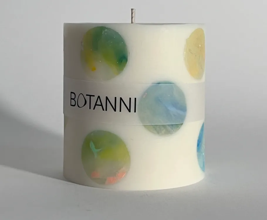 Decorative candle with colorful embedded stones.