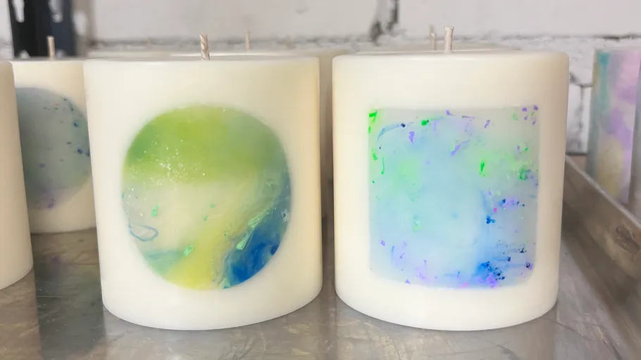 White candles with colorful designs on display.