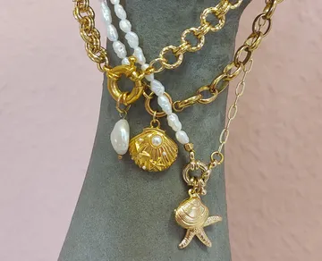 Gold and pearl necklaces on stone bust.