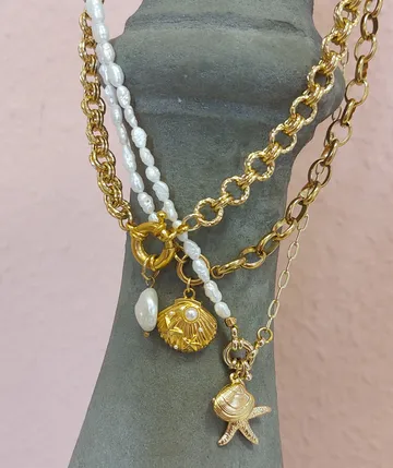 Gold and pearl necklaces on stone bust.