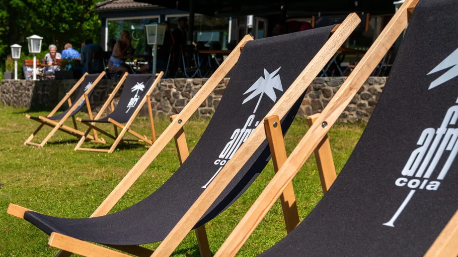 Deck chairs with logo on grass lawn.