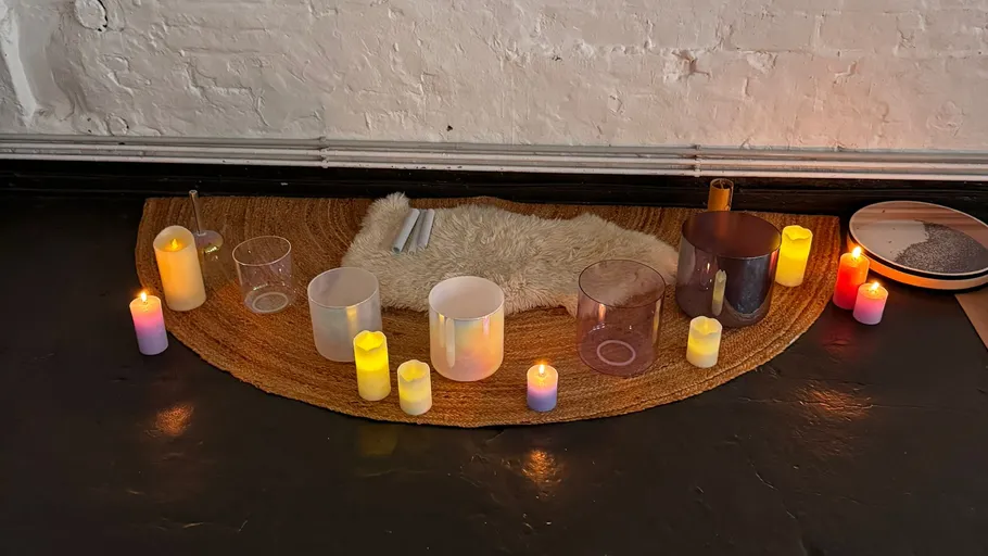 Kerzen und Schalen auf einer Matte drinnen.
