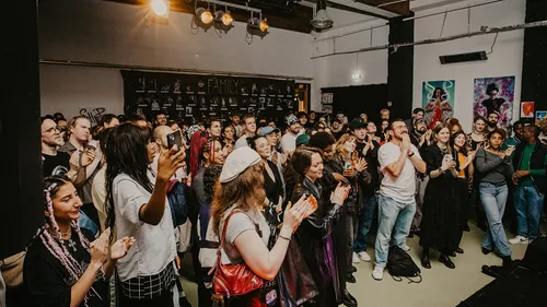 Diverse crowd applauding in a room.