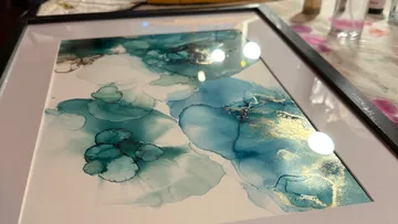 Abstraktes blau-goldenes Kunstwerk im Rahmen.