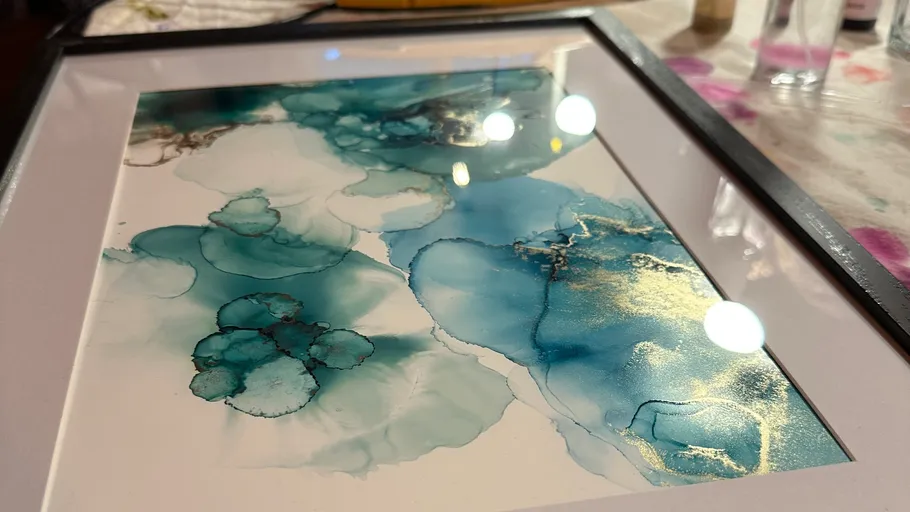 Abstract blue and gold artwork in a frame.