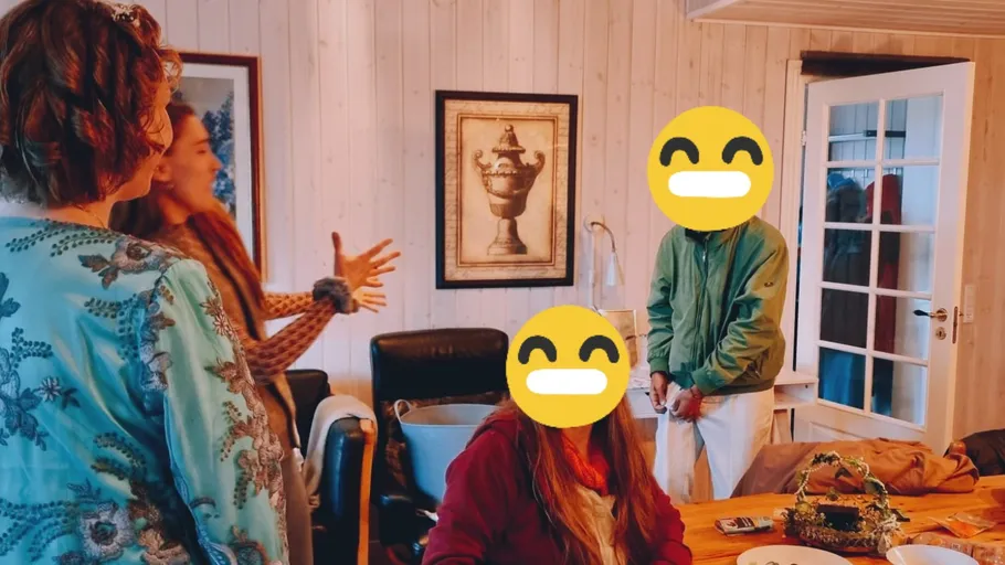 People talking and standing in a cozy room.