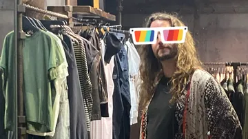 Mann mit langen Haaren im Bekleidungsgeschäft.