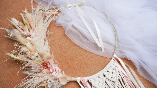 Boho-Traumfänger mit Blumen auf Korkhintergrund.
