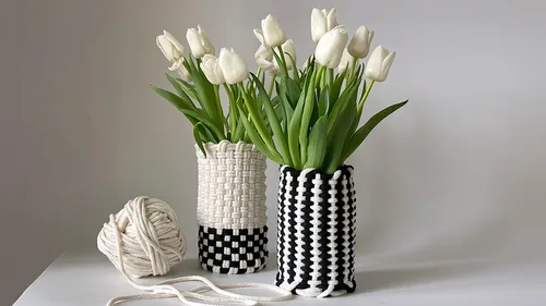Macrame vases with white tulips on table.