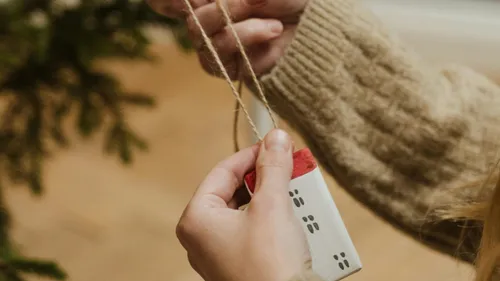 Person holding string, adjusting holiday ornament.