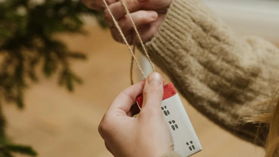 Person holding string, adjusting holiday ornament.