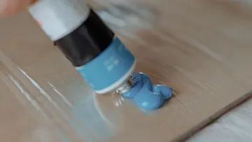 Blue paint squeezed onto a cardboard surface.