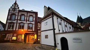 Half-timbered buildings in a quaint street at sunset.