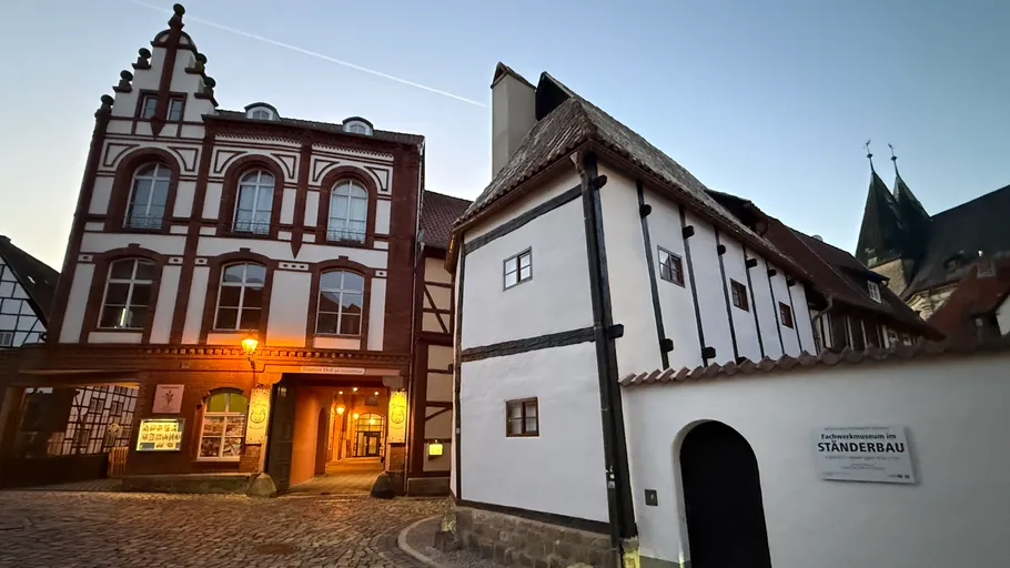 Historic buildings at dusk on cobblestone street.