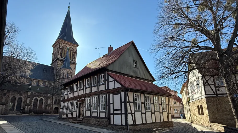 Half-timbered house with church tower in background.