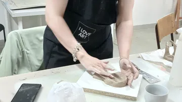 Frau gestaltet Ton im Kunststudio.
