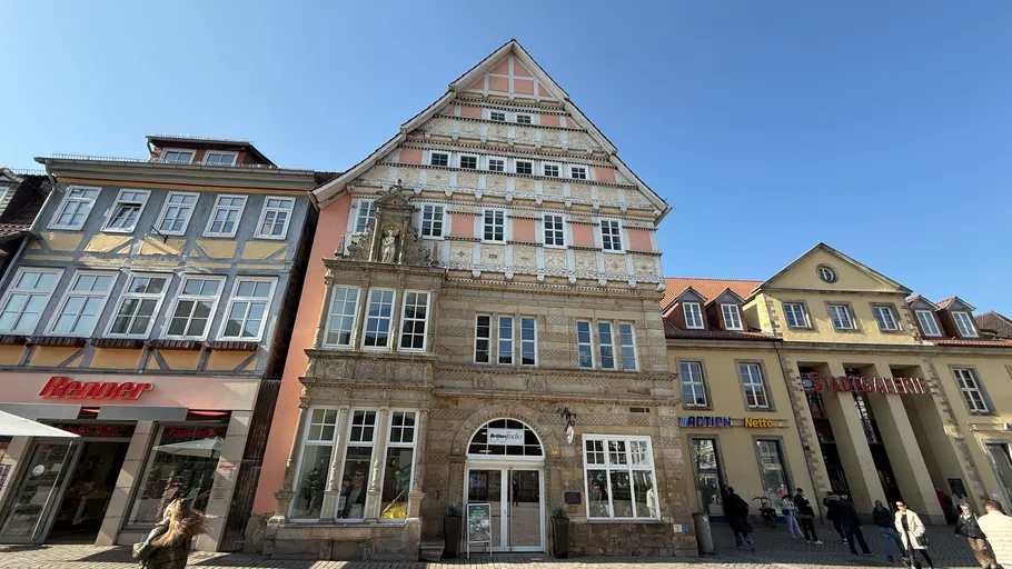 Historic half-timbered house on vibrant street.