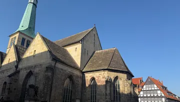 Historic church beside traditional half-timbered houses.