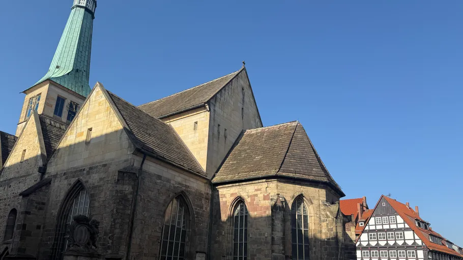 Church with pointed tower under clear sky.