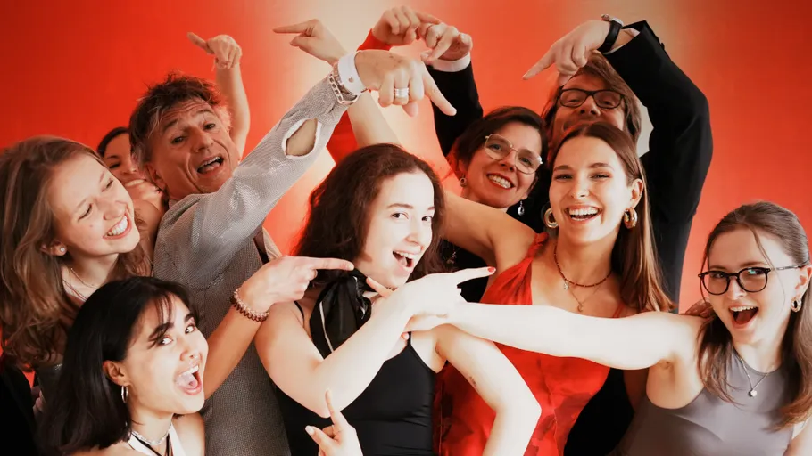Group of smiling people pointing joyfully.
