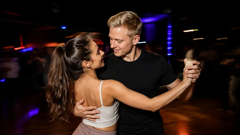 Couple dancing closely in dimly lit room.