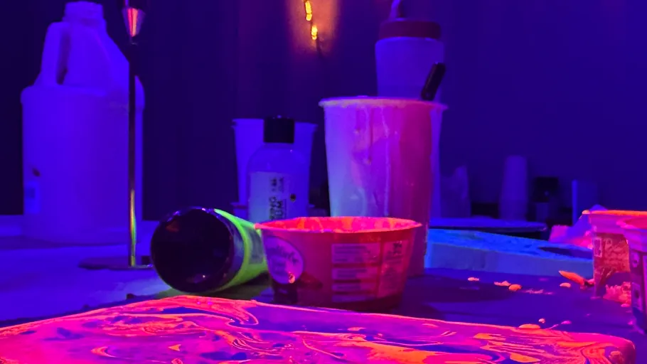 Neon-lit table with art supplies scattered around.