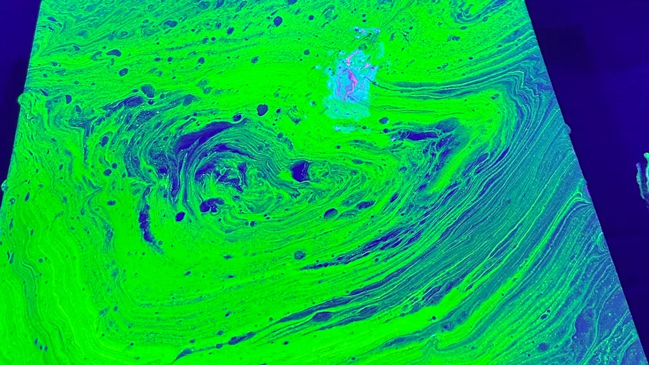 Fluorescent green liquid with swirling patterns.