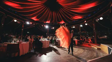 Tänzer in rot beleuchtetem eleganten Veranstaltungsort.