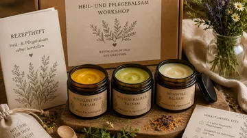 Drei Kräuterbalsame mit Rezeptheft und Blumen.