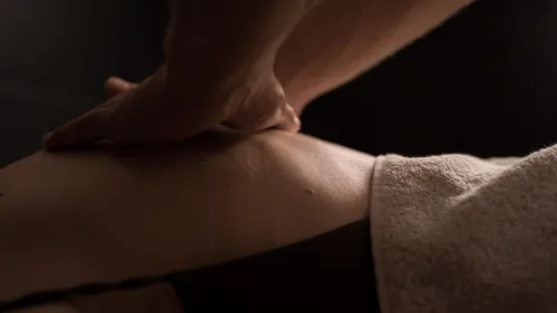 Close-up of hand massaging a person's back.