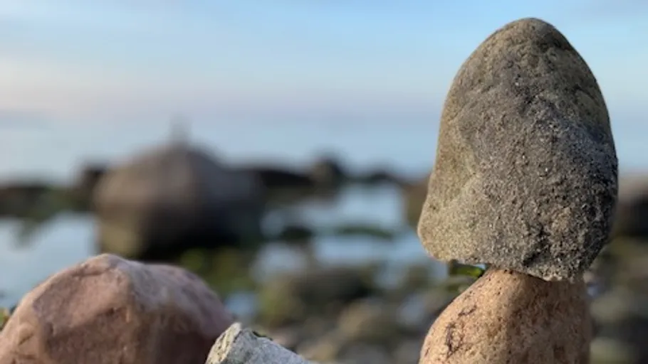 Stacked stones by the sea with blurred background.